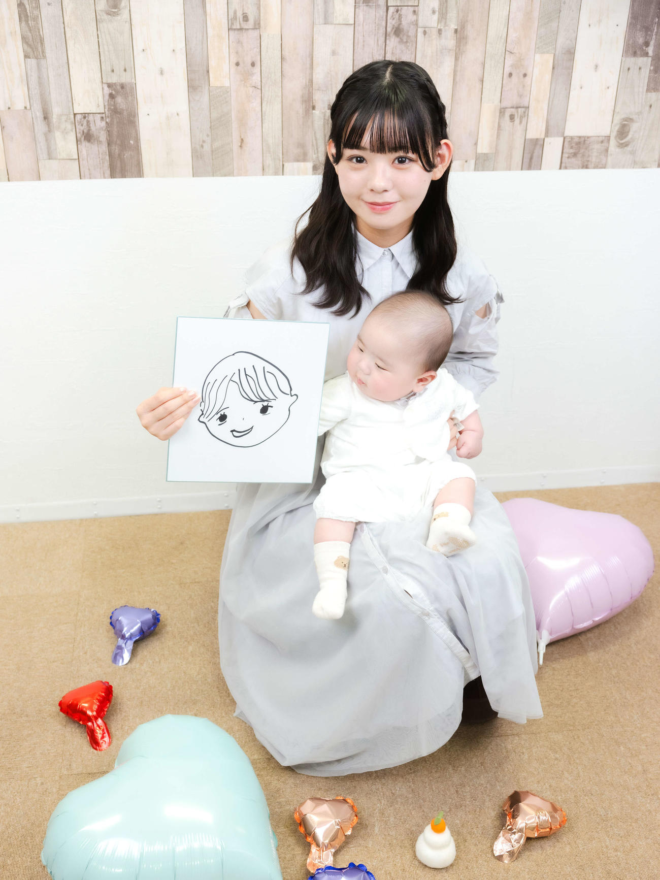夫の似顔絵を手に赤ちゃんと写真に納まる宮里莉羅（2025年12月撮影）