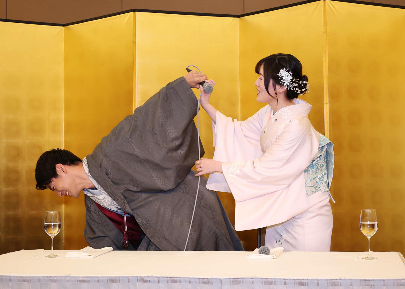 結婚記者会見に登壇しマイクのひもがひっかかり、それを直すBOYS AND MEN辻本達規（左）と助ける松井珠理奈（撮影・増田悦実）
