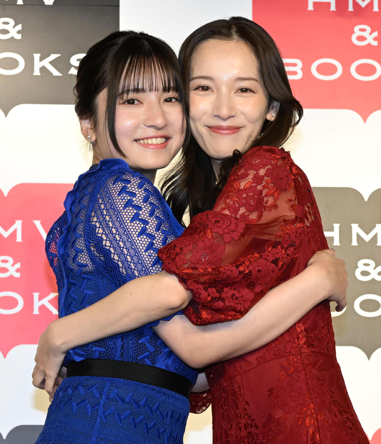 姉妹初の写真集「とまるtoとまる」の発売記念イベントでハグして仲の良さをアピールする都丸紗也華（右）と亜華梨姉妹（撮影・千葉一成）