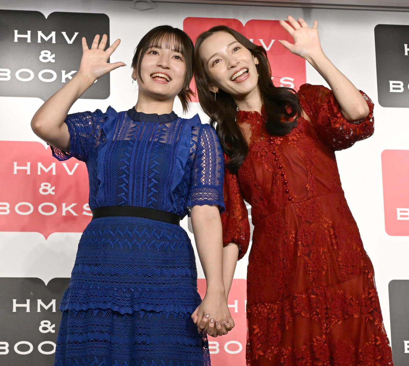 姉妹初の写真集「とまるtoとまる」の発売記念イベントで手をつないで仲の良さをアピールする都丸紗也華（右）と亜華梨姉妹（撮影・千葉一成）