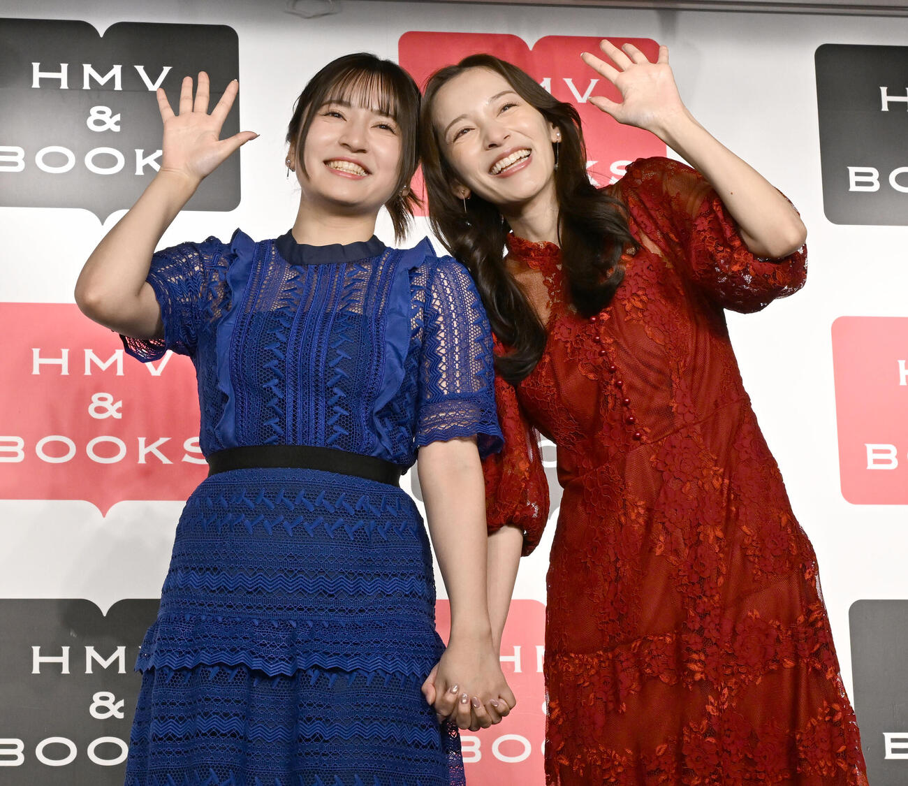 姉妹初の写真集「とまるtoとまる」の発売記念イベントで手をつないで仲の良さをアピールする都丸紗也華（右）と亜華梨姉妹（撮影・千葉一成）