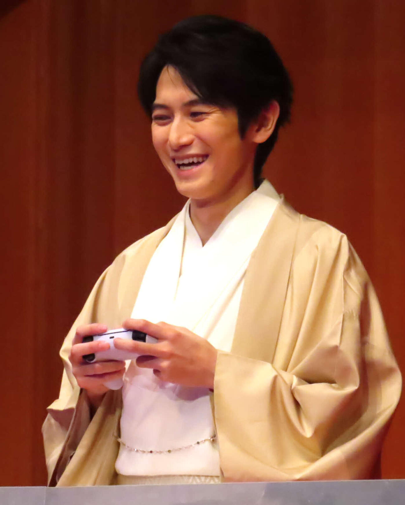 能楽堂の舞台上でゲームをする本郷奏多