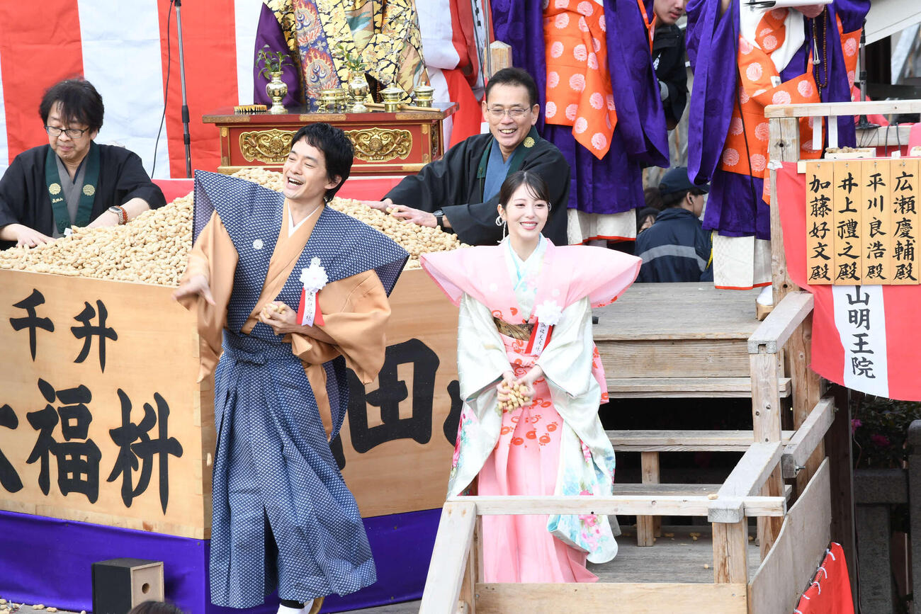 成田山不動尊（成田山大阪別院明王院）の節分祭で豆をまく池松壮亮（左）と浜辺美波（撮影・阪口孝志）