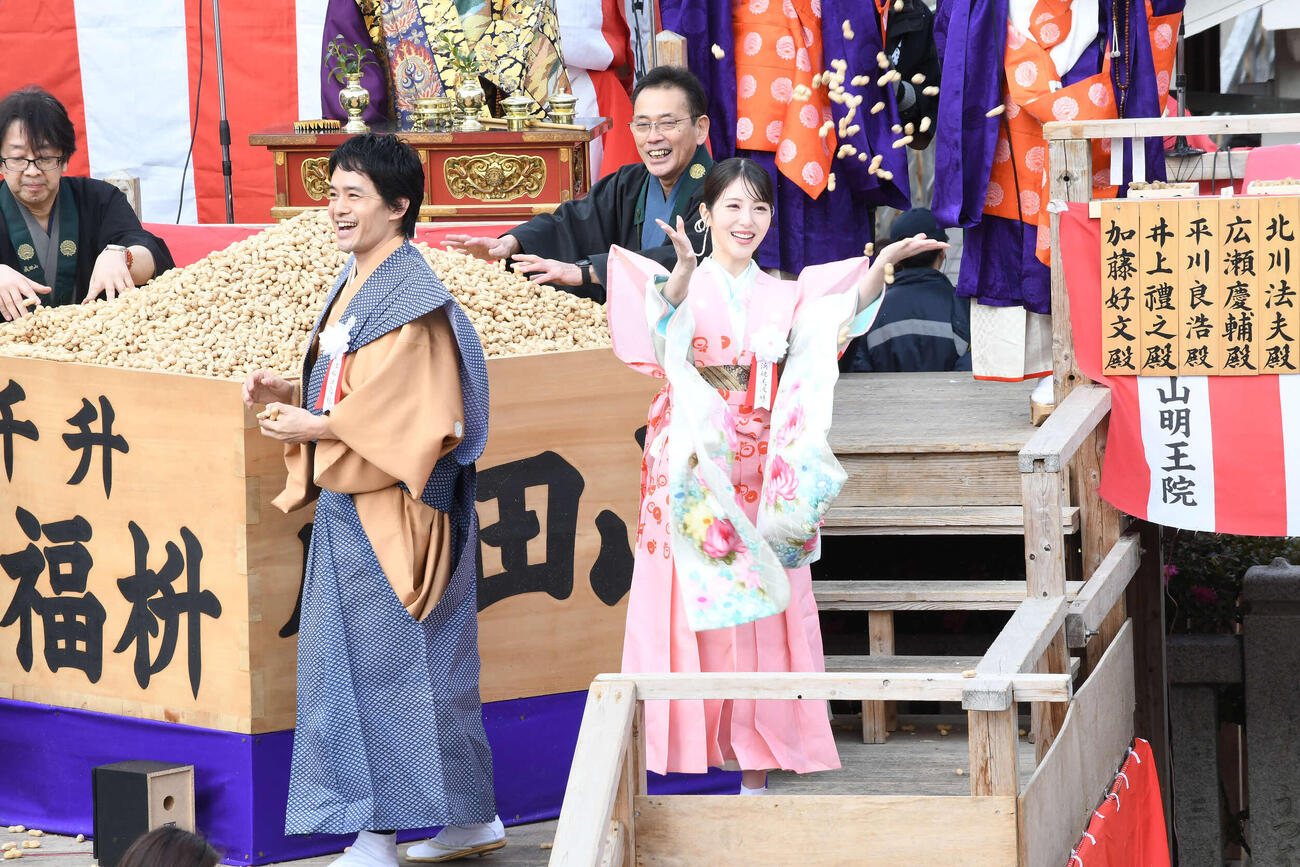 成田山不動尊（成田山大阪別院明王院）の節分祭で豆をまく池松壮亮（左）と浜辺美波（撮影・阪口孝志）