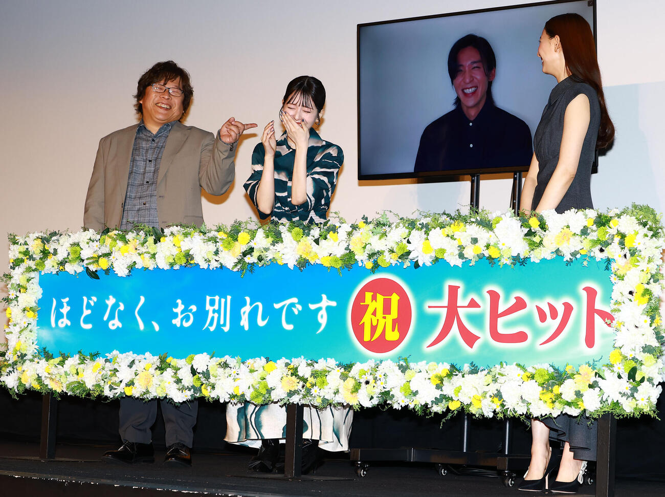 映画「ほどなく、お別れです」大ヒット御礼舞台あいさつに、中継で登場した目黒蓮（後方）と記念撮影する、手前左から三木孝浩監督、浜辺美波、新木優子（撮影・野上伸悟）