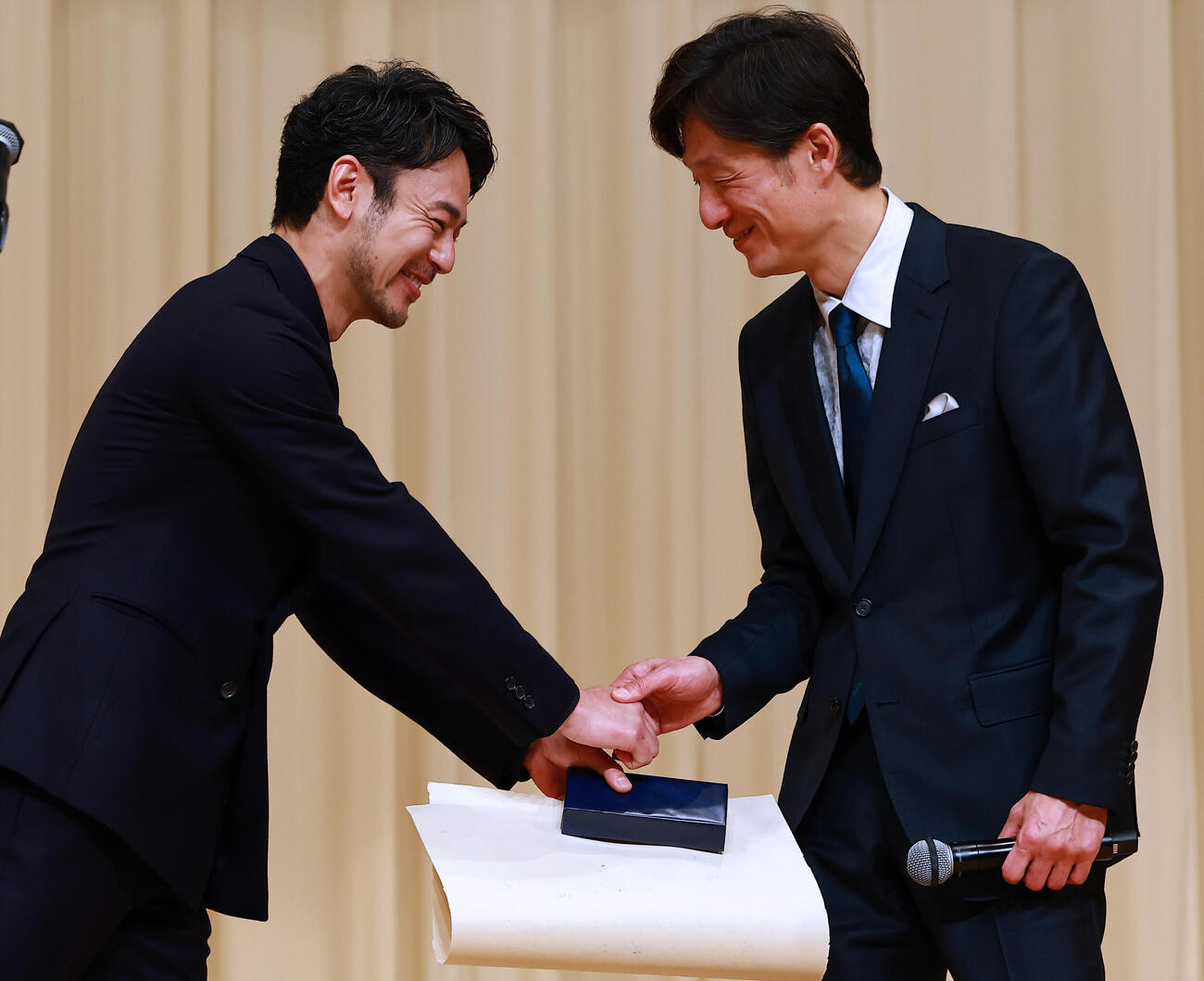 ブルーリボン賞授賞式で、作品賞「国宝」の李相日監督（右）の祝福を受ける主演男優賞の妻夫木聡（撮影・野上伸悟）