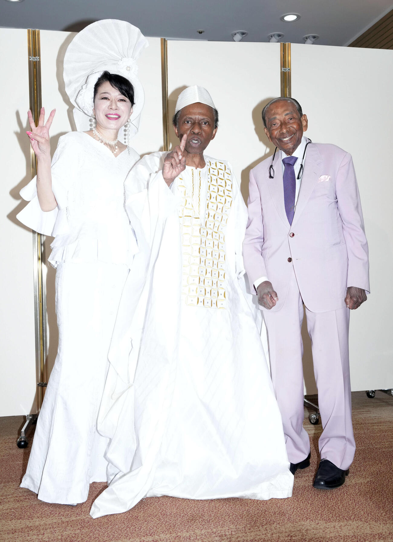 77歳の誕生日を迎え記念撮影に納まる、オスマン・サンコン（中央）。左は妻で歌手の北山みつき、右はウィッキーさん（撮影・たえ見朱実）