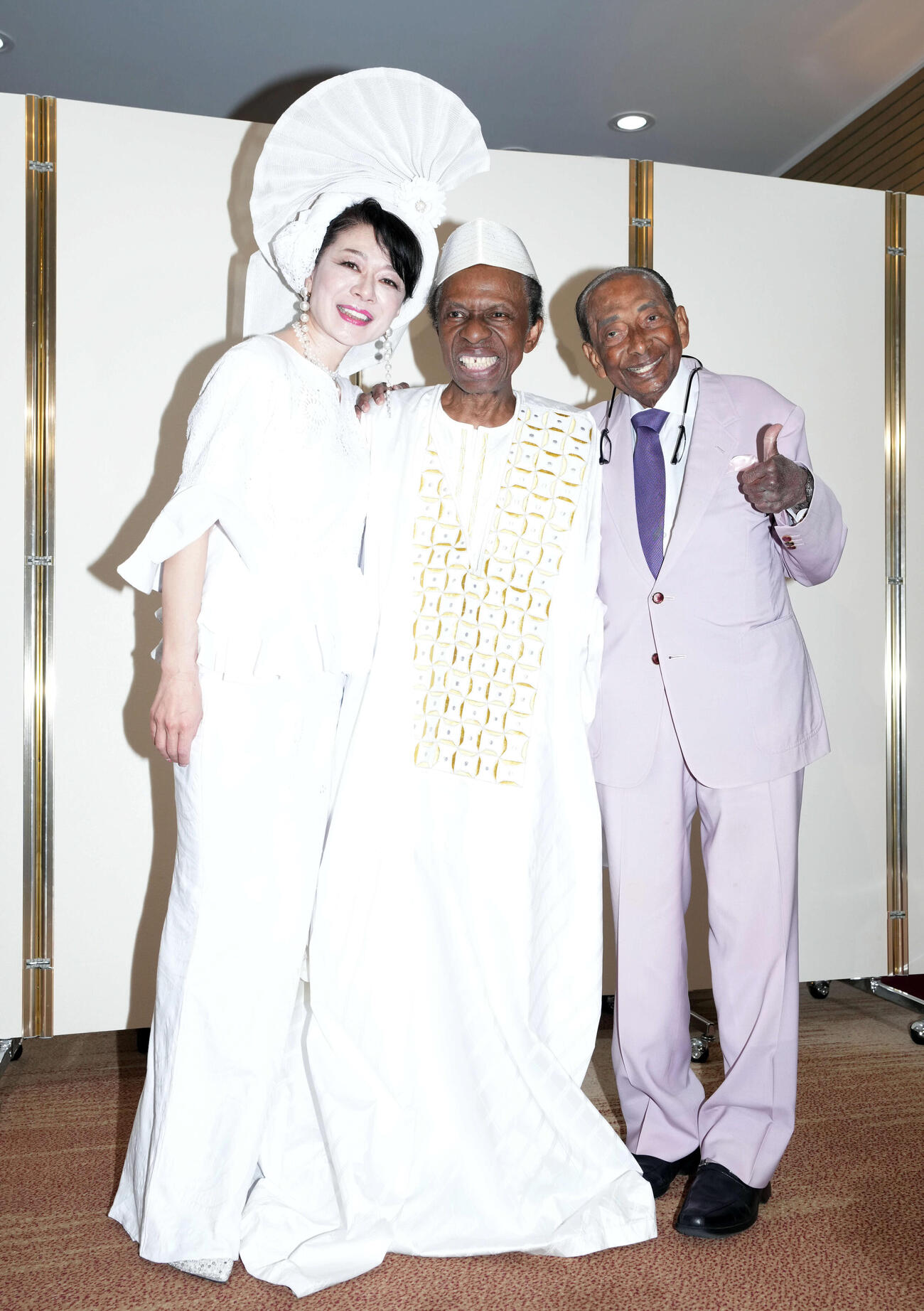 77歳の誕生日を迎え記念撮影に納まる、オスマン・サンコン（中央）。左から妻で歌手の北山みつき、1人おいてウィッキーさん（撮影・たえ見朱実）