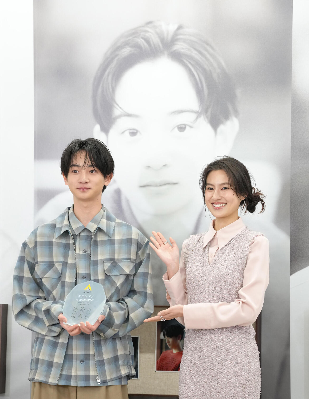 グランプリの大友隆佑さん（左）は恒松祐里から盾を受け取り笑顔