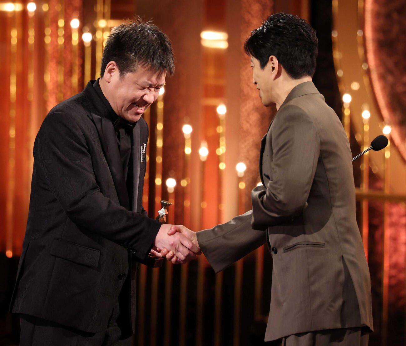 プレゼンターの大沢たかお（右）と握手を交わす最優秀助演男優賞を受賞した佐藤二朗（代表撮影）