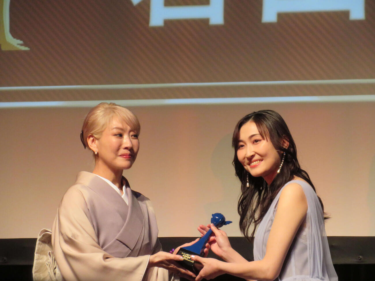 第二十回声優アワード授賞式で主演声優賞を受賞し、アンバサダーの朴〓（王ヘンに路）美からトロフィーを受け取る若山詩音（撮影・村上幸将）