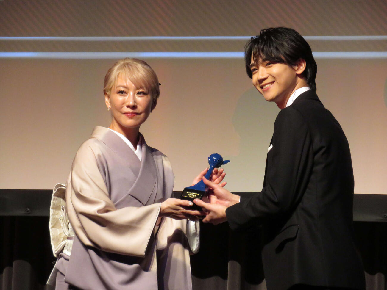 第二十回声優アワード授賞式で主演声優賞を受賞し、アンバサダーの朴〓（王ヘンに路）美からトロフィーを受け取る戸谷菊之介（撮影・村上幸将）