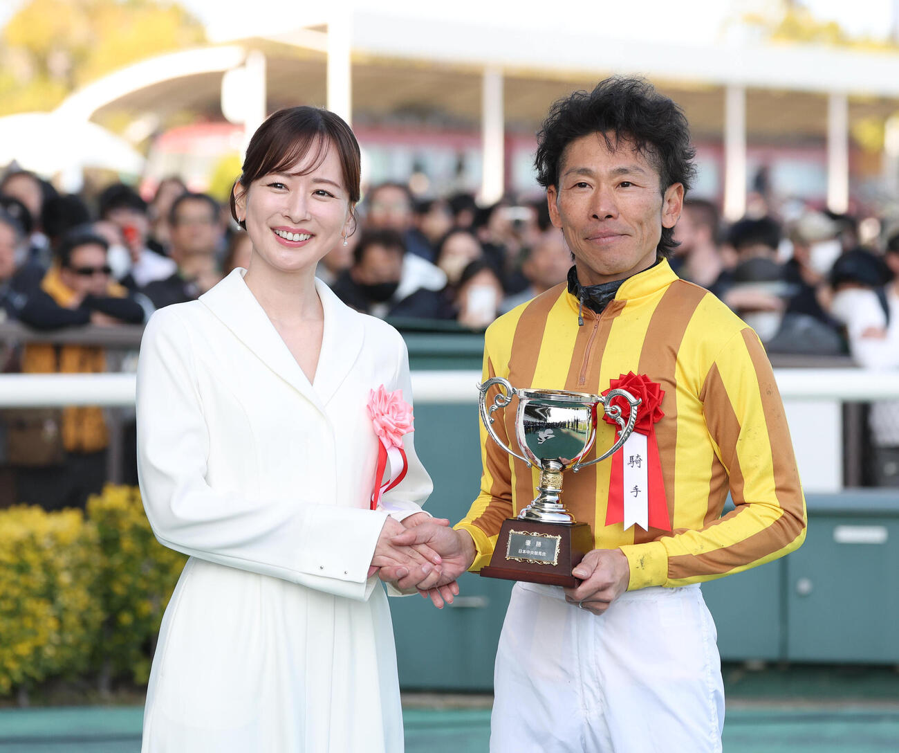 プレゼンターの皆藤愛子と握手する古川吉騎手（2026年3月15日撮影）
