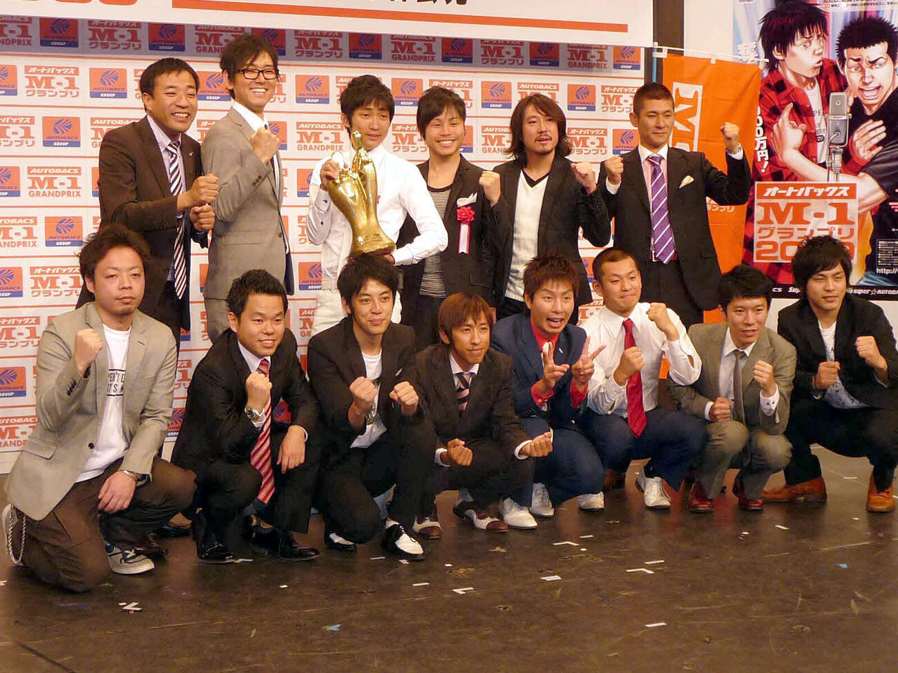 M−1グランプリ2009の会見に出席した前年のファイナリストら。前列左からダイアンの西沢裕介、津田篤宏、キングコングの西野亮廣、梶原雄太、U字工事の福田薫、益子卓郎、モンスターエンジンの西森、大林、後列左からナイツの塙宣之、土屋伸之、昨年優勝のNON STYLEの石田明、井上裕介、笑い飯の西田幸治、哲夫（2009年7月撮影）