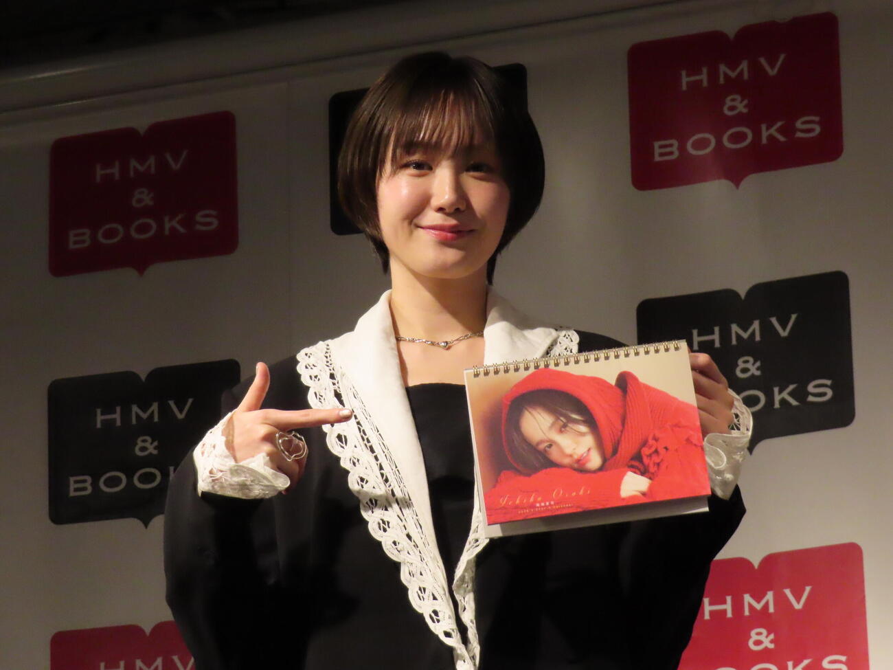 26年度カレンダーの表紙を指さす尾碕真花