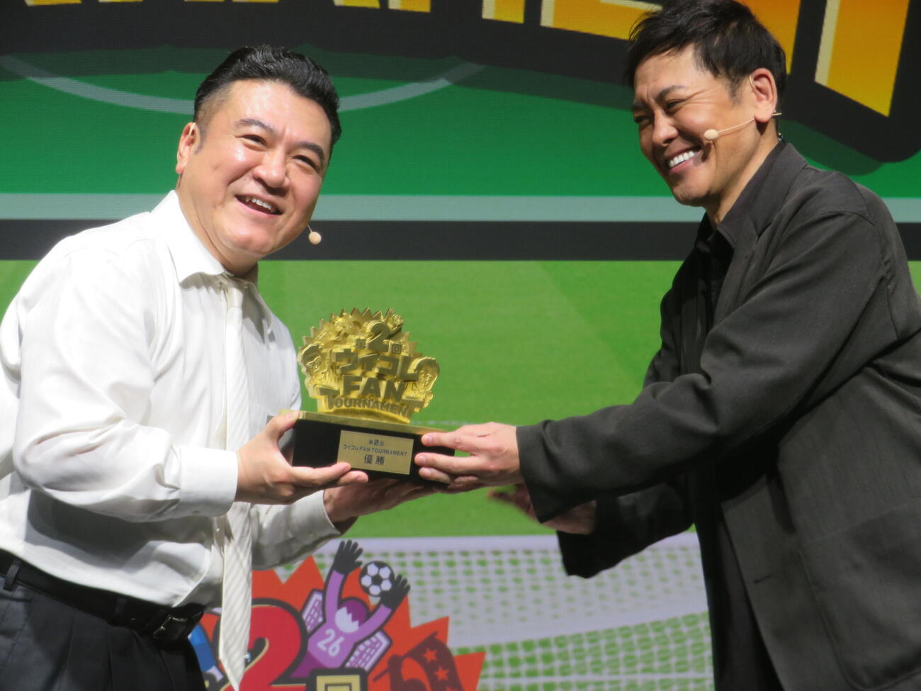 第2回「ウイコレFAN TOURNAMENT」2連覇達成で有田哲平（右）からトロフィーを受け取る山崎弘也（撮影・川田和博）