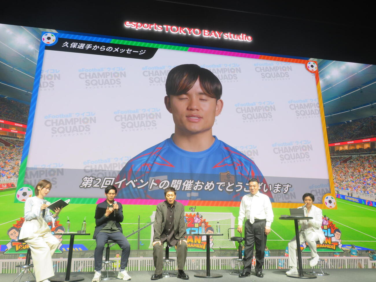 第2回「ウイコレFAN TOURNAMENT」にVTRメッセージを送った久保建英と見入る登壇者たち（撮影・川田和博）