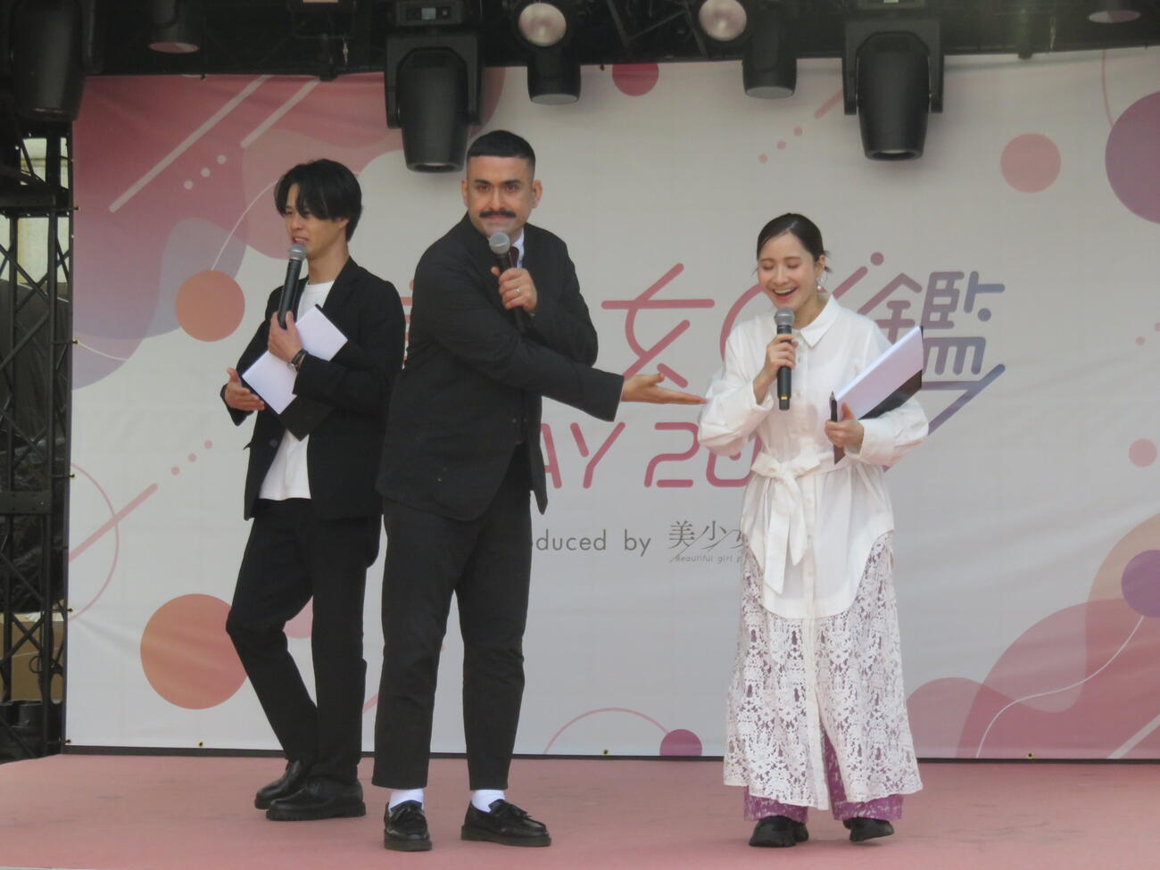 デニス植野行雄（中）は妻の比嘉梨乃（右）を紹介する。左は松下宣夫