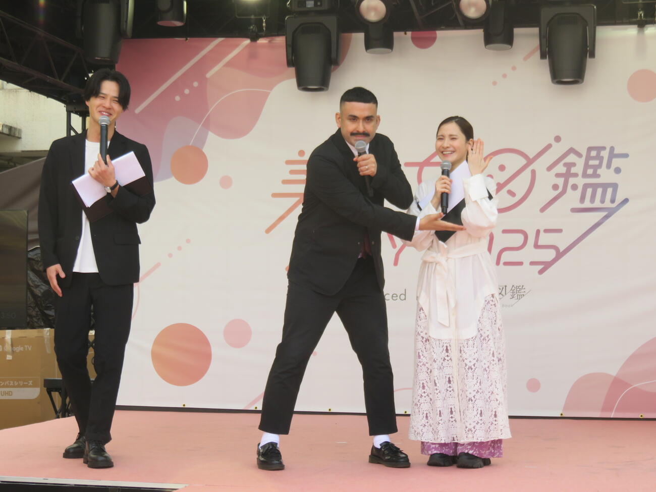 デニス植野行雄（中）は妻の比嘉梨乃（右）を紹介する。左は松下宣夫