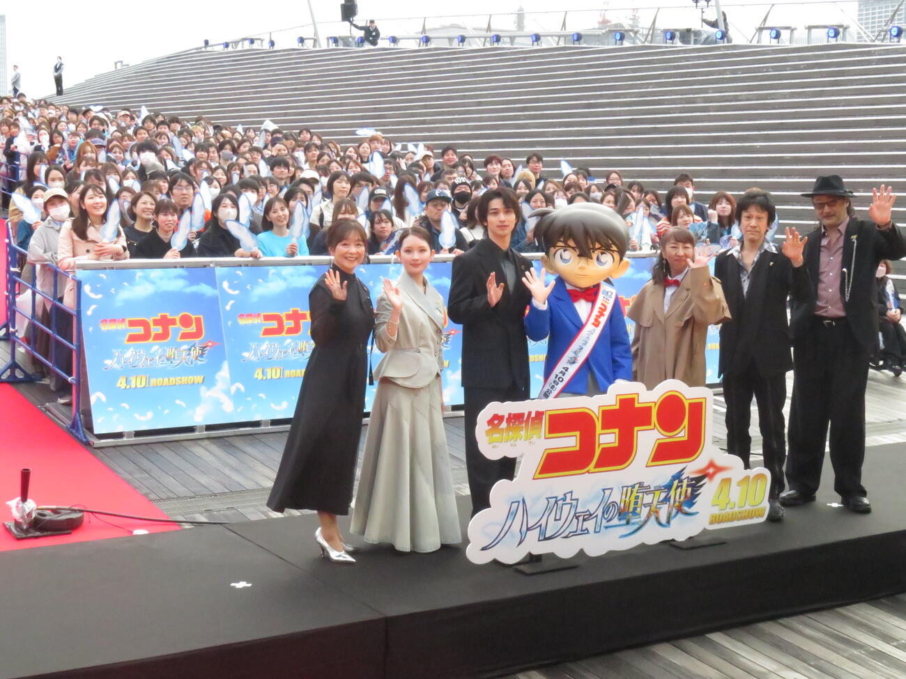 劇場版「名探偵コナン　ハイウェイの堕天使」風のSPファンミーティングに出席した左から日高のり子、畑芽育、横浜流星、江戸川コナン、高山みなみ、小山力也、大塚明夫は、集まった役850人の来場者を背に手を振って笑顔を見せた
