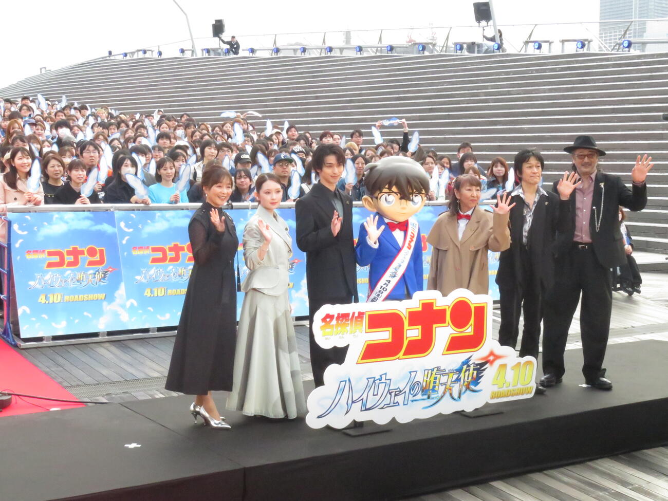 劇場版「名探偵コナン　ハイウェイの堕天使」風のSPファンミーティングに出席した左から日高のり子、畑芽育、横浜流星、江戸川コナン、高山みなみ、小山力也、大塚明夫は、集まった役850人の来場者を背に手を振って笑顔を見せた