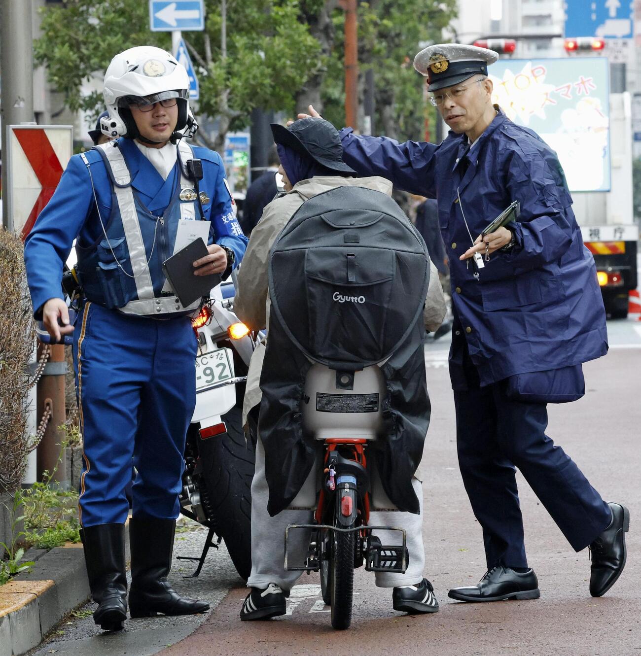 16歳以上の自転車の交通違反に反則金納付を通告できる交通反則切符（青切符）制度が始まり、東京都北区の交差点付近で利用者に指導する警察官（共同）