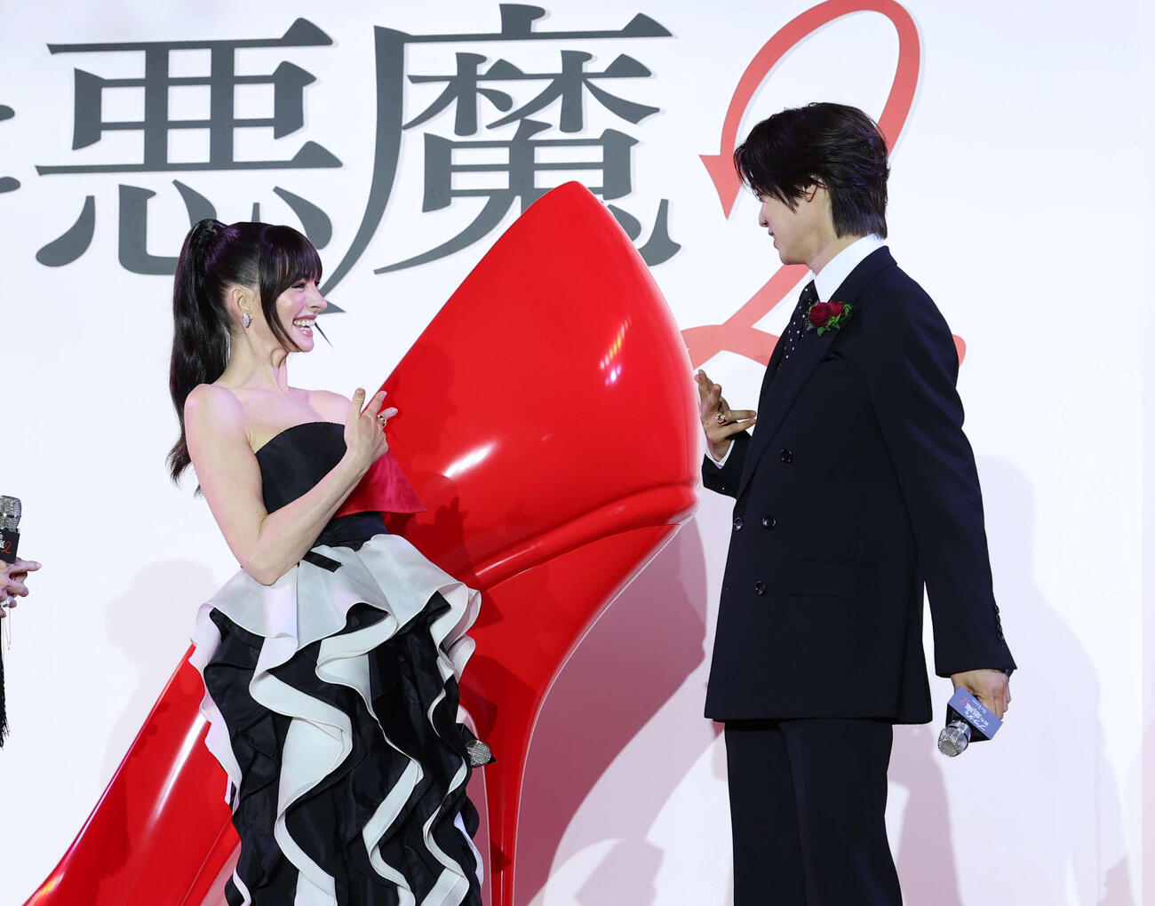 来日スペシャルイベントで＆TEAMのK（右）が登場し「K」ポーズをするアン・ハサウェイ（撮影・増田悦実）
