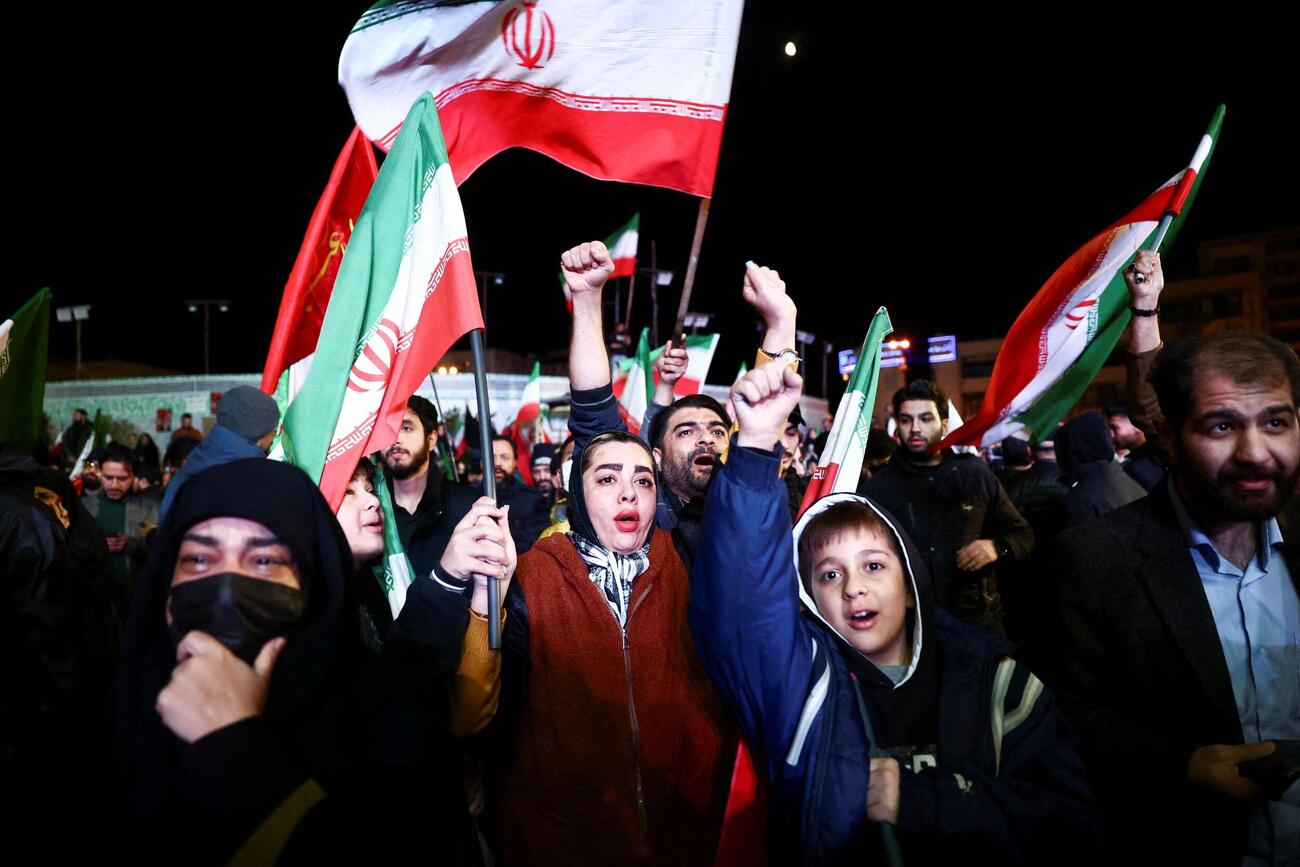 イラン・テヘランで集まり旗を振る人たち＝8日（WANA提供・ロイター＝共同）