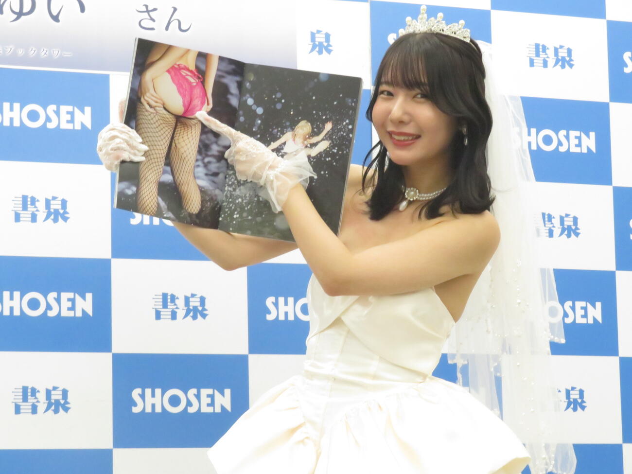 初の写真集発売記念イベントに先立ち、お気に入りショットを指さし笑顔を見せる奥ゆい