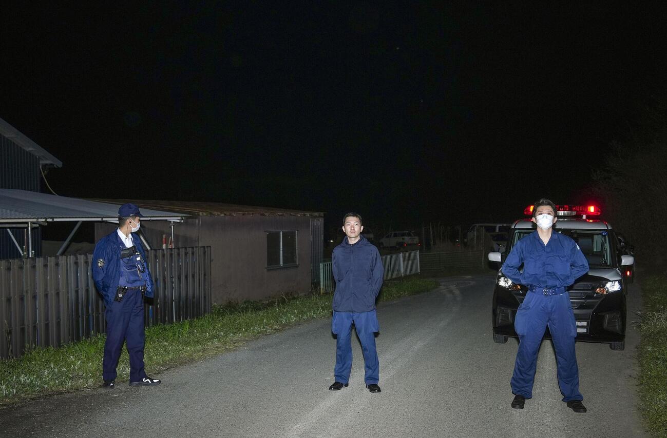 身元不明の遺体が見つかった京都府南丹市の現場付近を警戒する捜査員ら＝13日午後8時11分(共同)