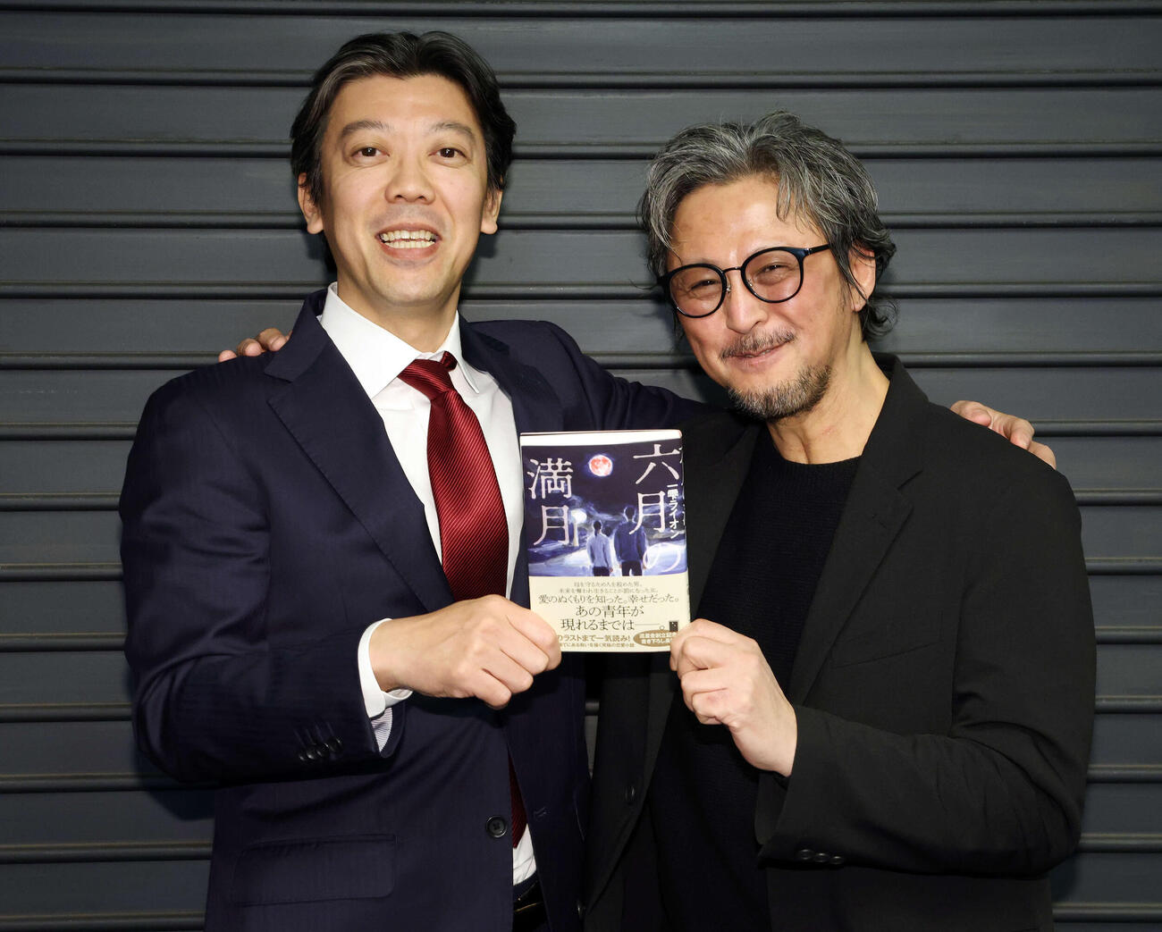 新作小説「六月の満月」を発売した一雫ライオン氏（右）は流星舎代表取締役の有馬大樹氏と笑顔で肩を組む（撮影・宮地輝）