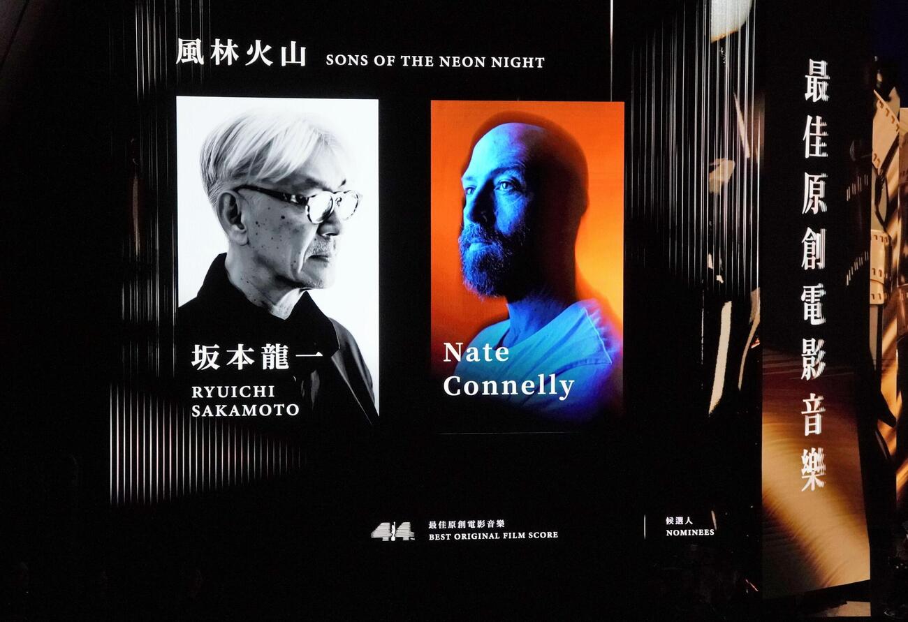 金像奨の授賞式でモニターに映された坂本龍一さんの写真（左）＝19日、香港（共同）