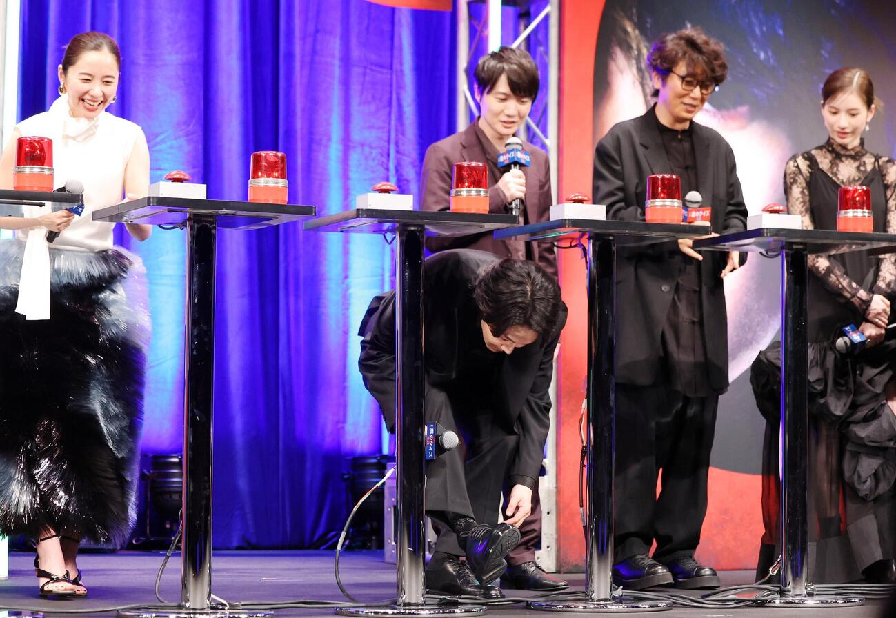 映画「君のクイズ」完成披露試写会に登壇した中村倫也（中央）はクイズ形式の質問後、質問台をくぐって前に出る（撮影・浅見桂子）