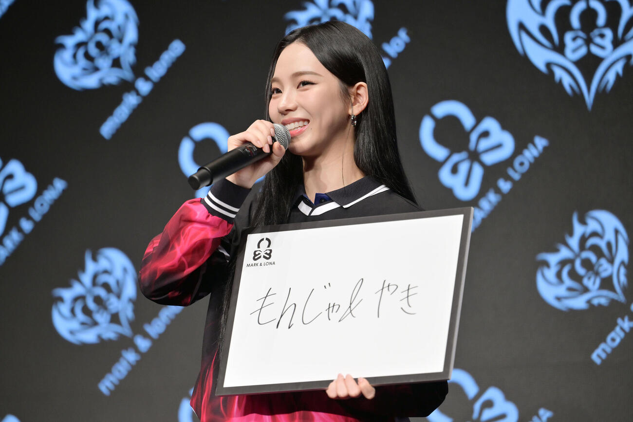 「もんじゃ＆やき」と記したパネルを手にするKARINA（撮影・滝沢徹郎）