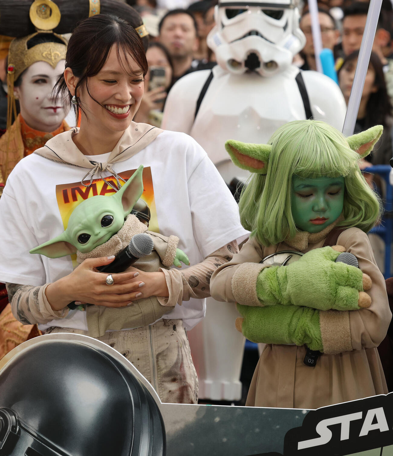 「スター・ウォーズの日」イベントでマイクを落としそうになり必死で抱える永尾柚乃。左は佐々木久美（撮影・水谷安孝）