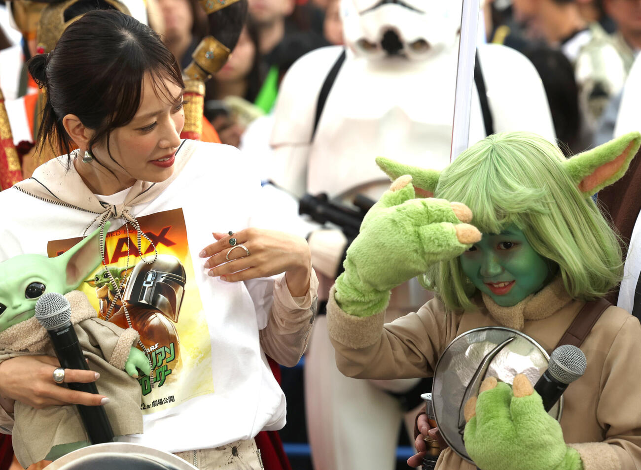 「スター・ウォーズの日」イベントにグローグーのコスプレで登壇した永尾柚乃は髪型を気にする。左は佐々木久美（撮影・水谷安孝）