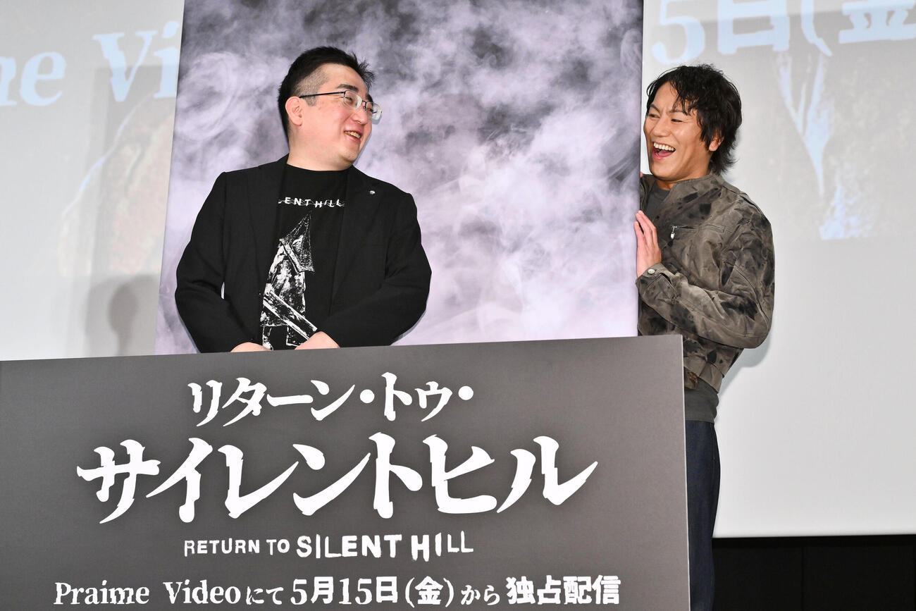 映画「リターン・トゥ・サイレントヒル」スペシャル試写会イベントでパネルの裏から顔を出す狩野英孝（右）と岡本基氏（撮影・滝沢徹郎）
