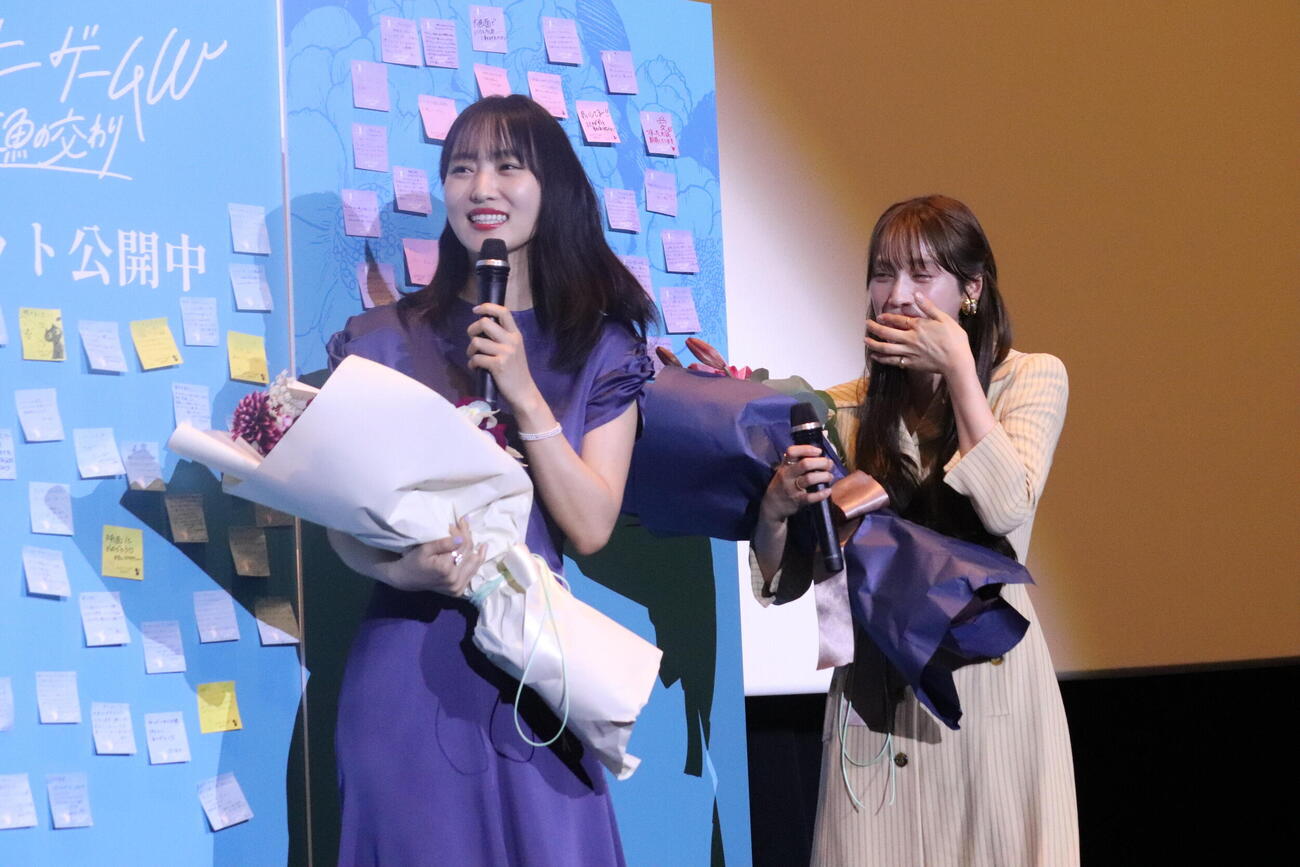 映画「チェイサーゲームW　水魚の交わり」初日舞台あいさつで岡本望来から花束を贈呈され喜ぶ菅井友香（左）と中村ゆりか
