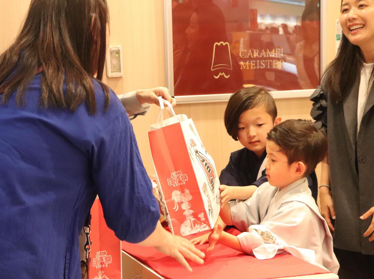 「江戸祭　人形焼」の販売イベントでファンに人形焼を手渡しする中村陽喜（左）、夏幹
