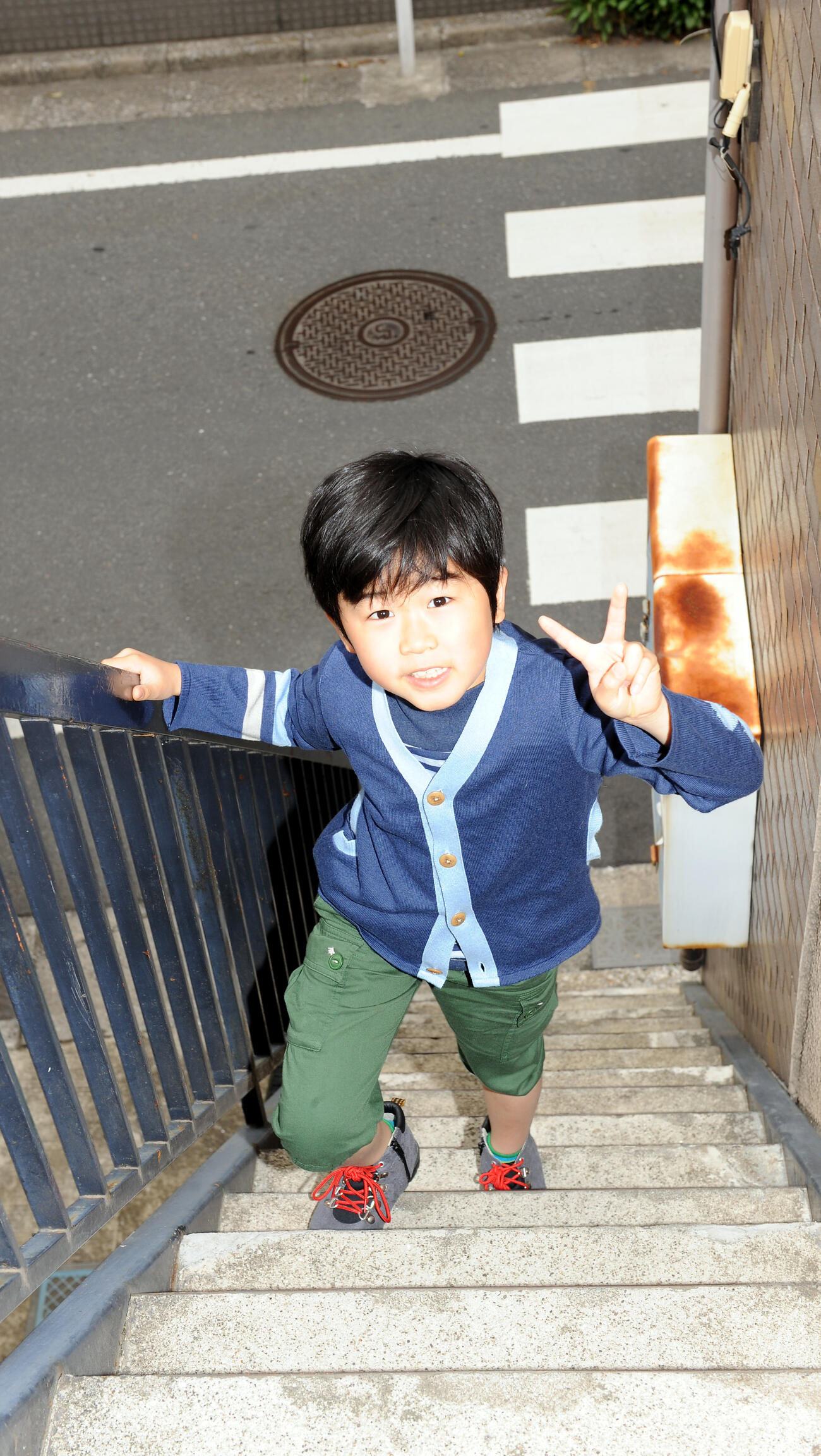 春日が住むのアパートを訪れ、うれしそうにVサインをつくる鈴木福（2012年4月撮影）
