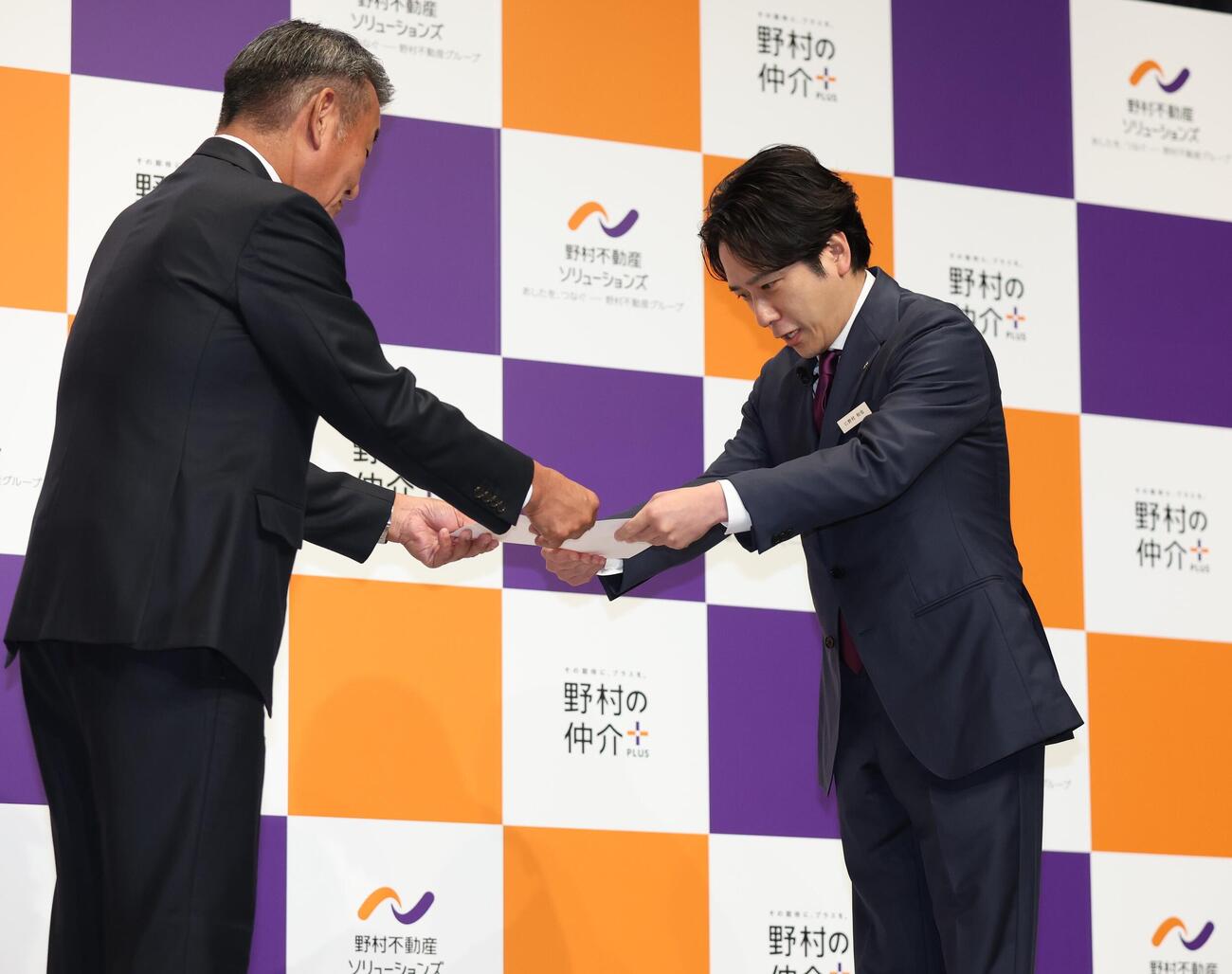 野村不動産ソリューションズ新ブランド戦略＆新CM発表会　日比野勇志社長（左）から社員として辞令交付される二宮和也（撮影・黒川智章）