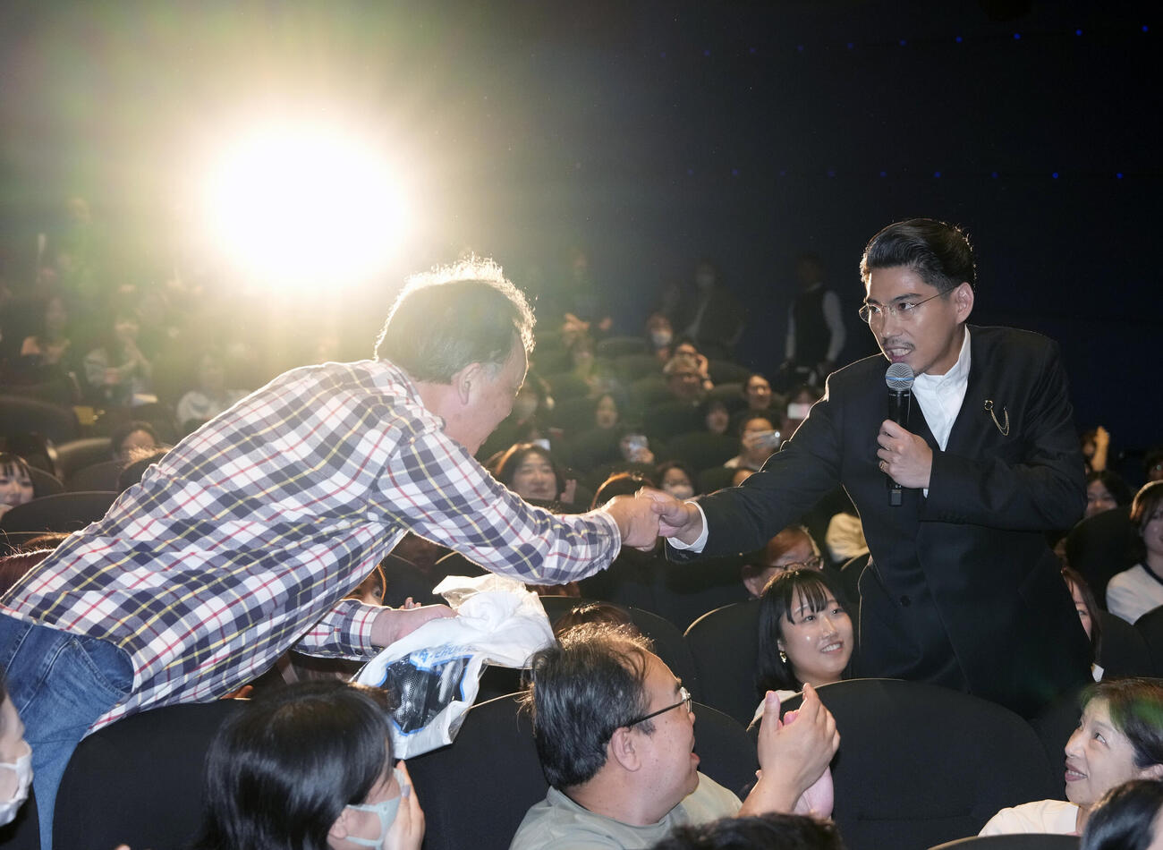 映画「NeverAfterDark／ネバーアフターダーク」初日舞台あいさつでオリジナルグッズを手渡しでプレゼントする賀来賢人（右）（撮影・小島史椰）