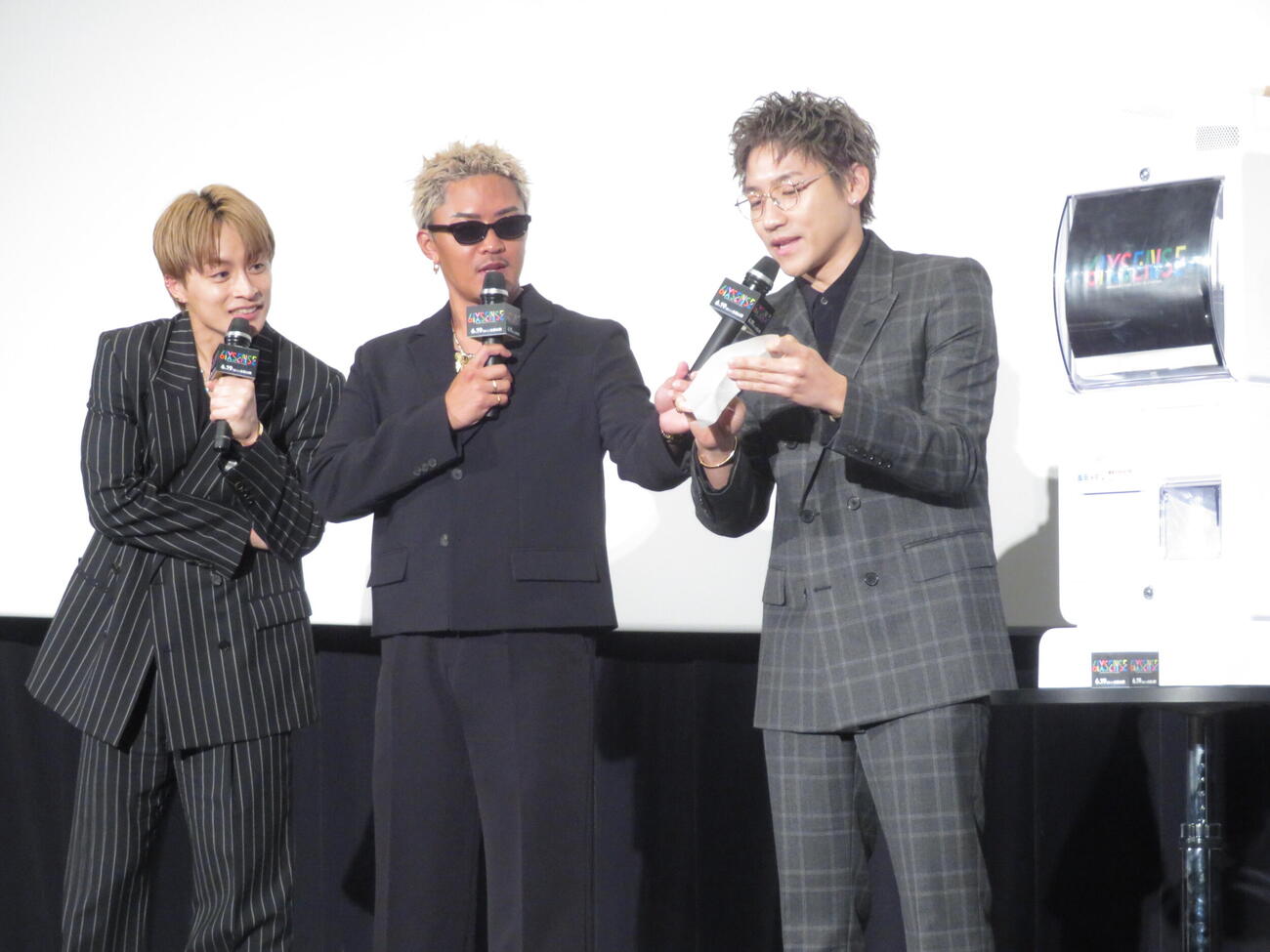 ドキュメンタリー映画「GENERATIONS　“6IX SENSE”　LIVE IN CINEMA」プレミア先行上映舞台あいさつでクジを引く小森隼（右）、のぞきこむ（左から）白濱亜嵐、数原龍友