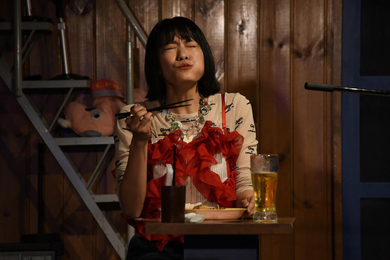 弾き語り＆トークイベント「また来たでオカン！」で豚キムチをほおばり大満足の岸本ゆめの（撮影・阪口孝志）