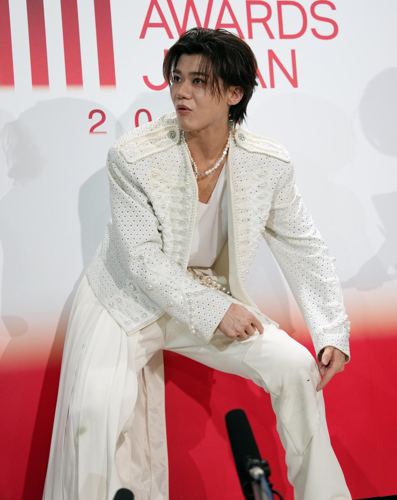 MUSIC AWARDS JAPAN2026　演歌・歌謡曲LIVE囲み取材で膝の汚れ対策の説明をする新浜レオン（撮影・小島史椰）