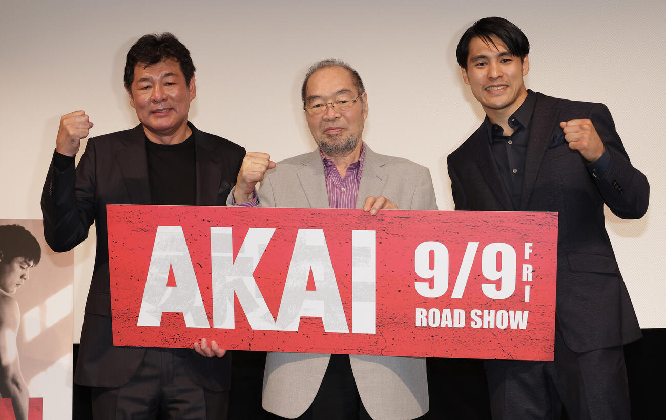 映画「AKAI」の舞台あいさつでガッツポーズする、左から主演の赤井英和、ガッツ石松氏、赤井英五郎監督（2022年8月撮影）