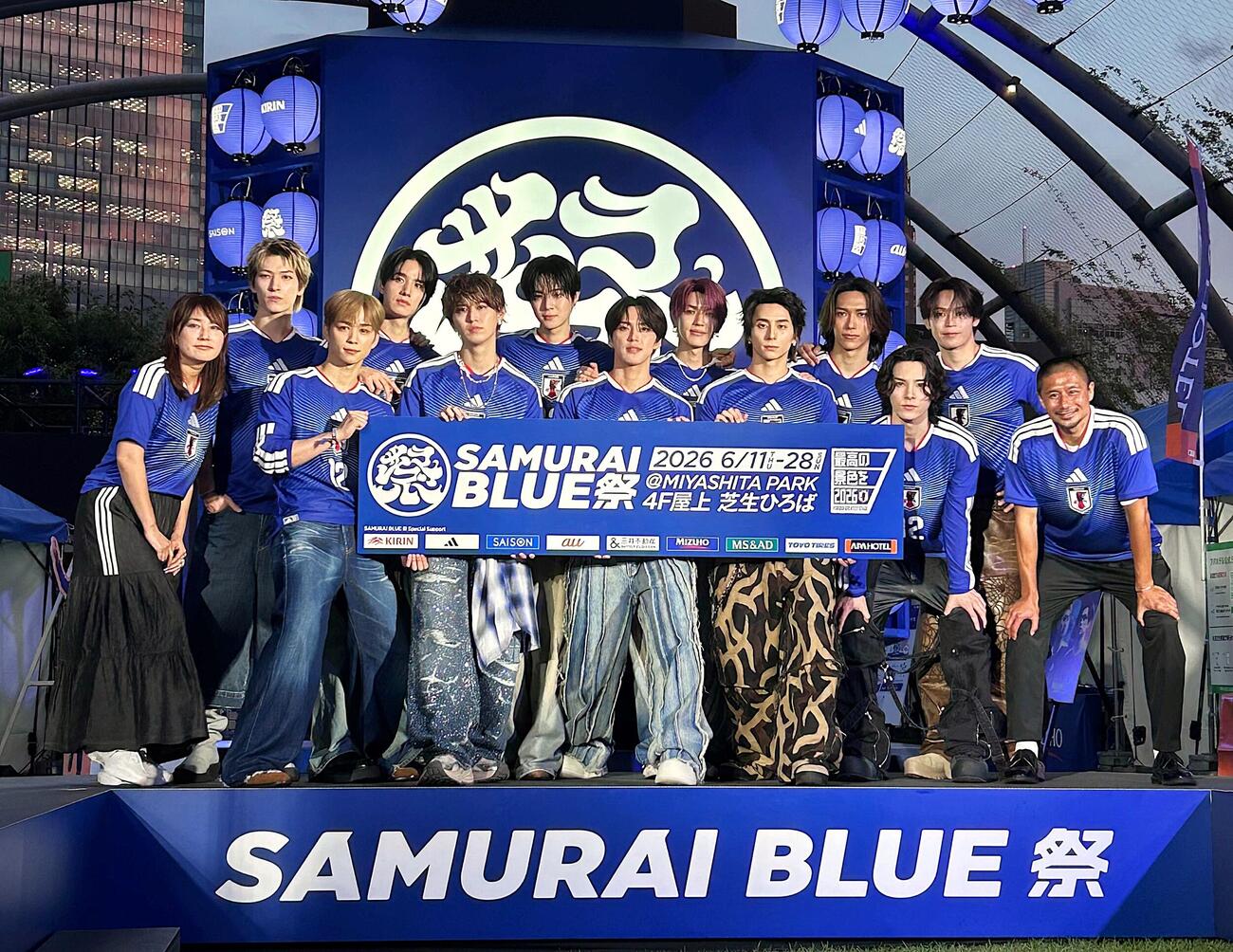 「SAMURAI BLUE祭　点灯式」に出席したスペシャルユニット「JI BLUE」のメンバーと坪井慶介氏（前列右端）、司会の細田阿也（同左端）