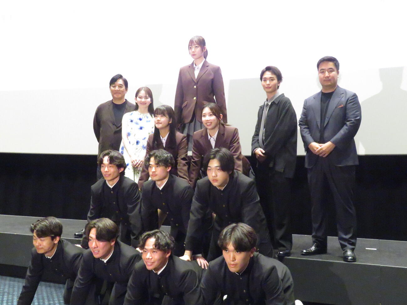 日体大の体操部員が組体操を披露する中、映画「NEW GROUP」の舞台あいさつで写真撮影に臨んだ後列左からピエール瀧、山田杏奈、青木柚、下津優太監督
