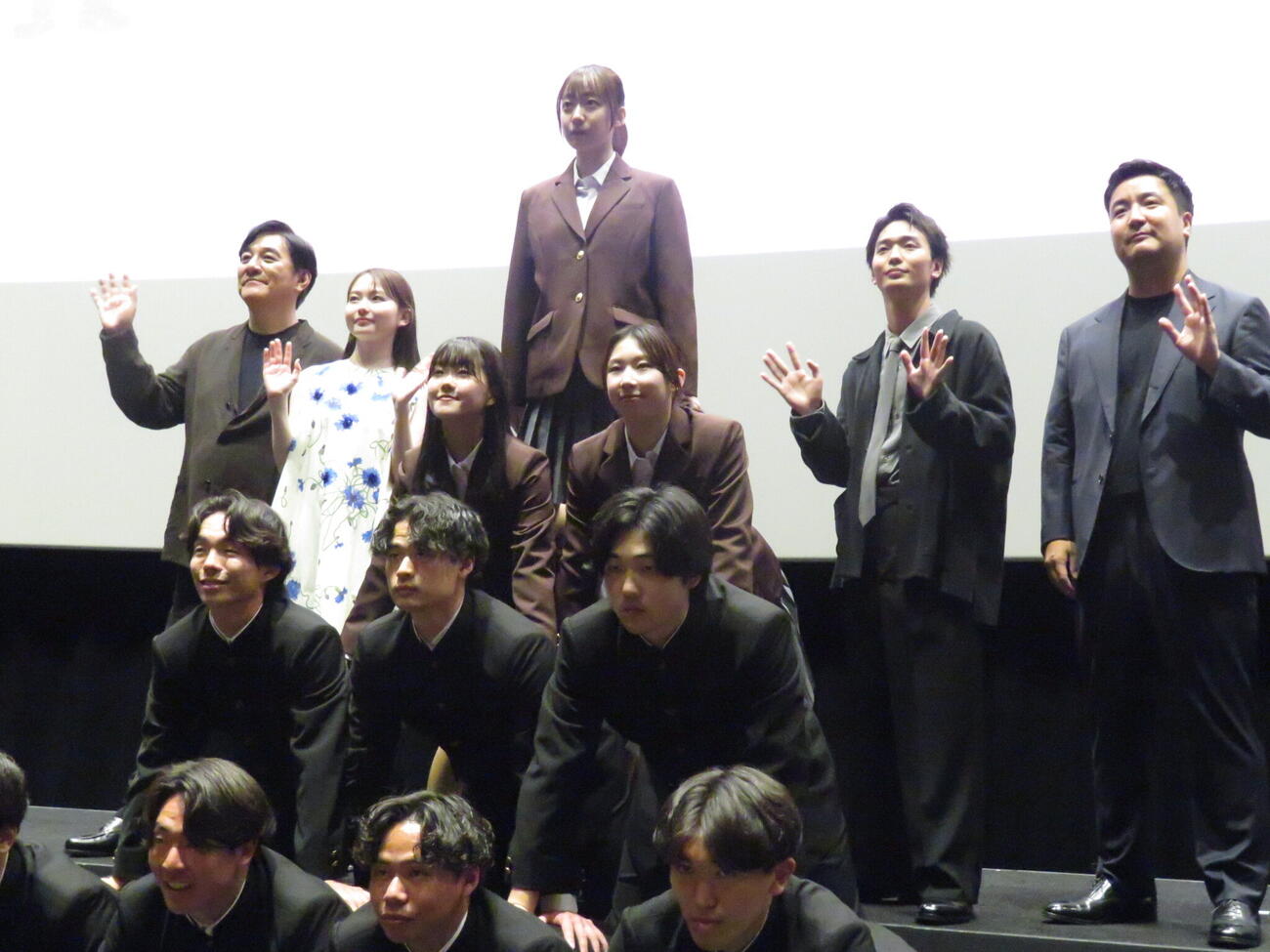 日体大の体操部員が組体操を披露する中、映画「NEW GROUP」の舞台あいさつで写真撮影に臨んだ後列左からピエール瀧、山田杏奈、青木柚、下津優太監督