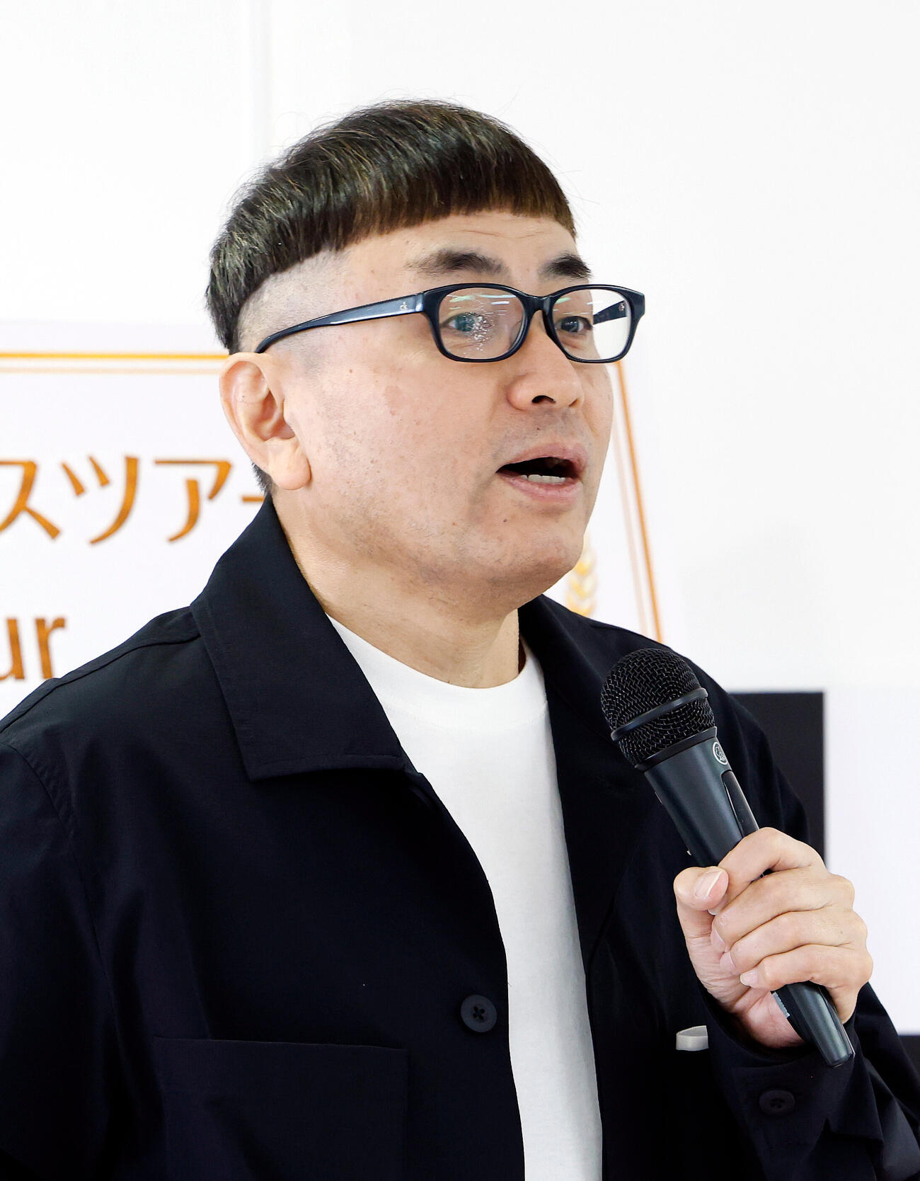 MINAMO記者発表＆ファンイベント　イベントでMINAMOの歯ブラシを手に取り、水しぶきをメガネのレンズにかけたイジリー岡田（撮影・山本朝陽）